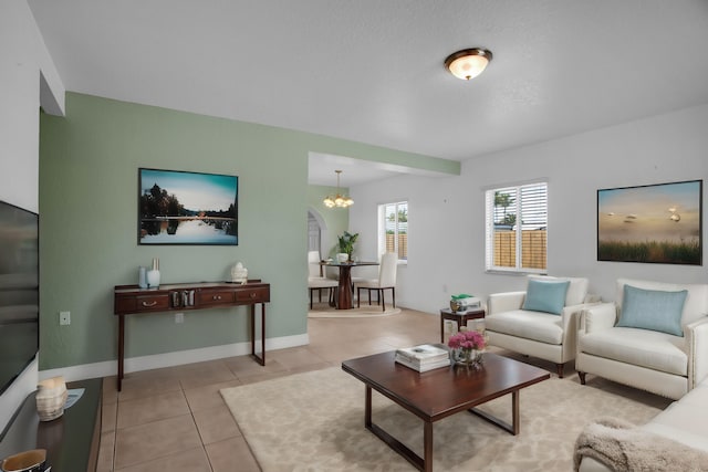 tiled living room featuring a chandelier