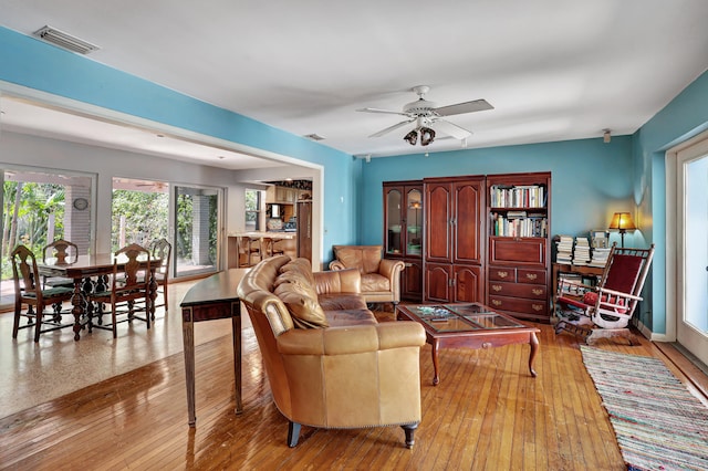 living room with ceiling fan and light hardwood / wood-style flooring