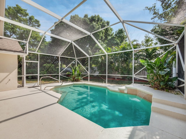 view of swimming pool with a lanai, pool water feature, and a patio area