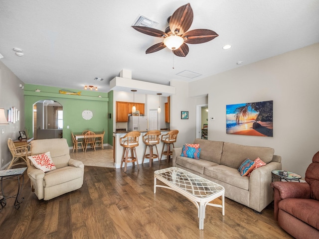 living room with ceiling fan and dark wood-type flooring