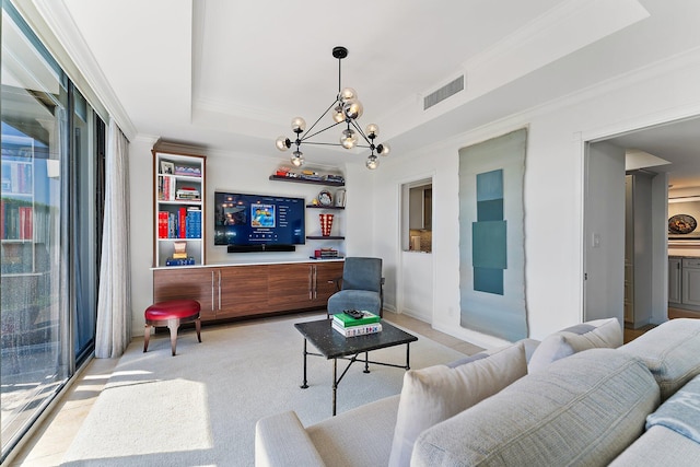 living room featuring crown molding, a raised ceiling, and a chandelier