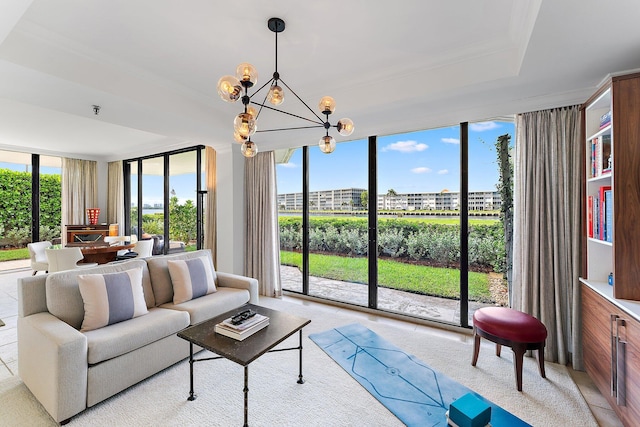 living room with expansive windows, a raised ceiling, and an inviting chandelier