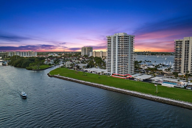 aerial view at dusk featuring a water view