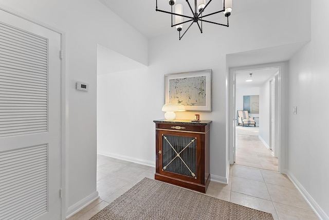 hall featuring light tile patterned floors and a chandelier