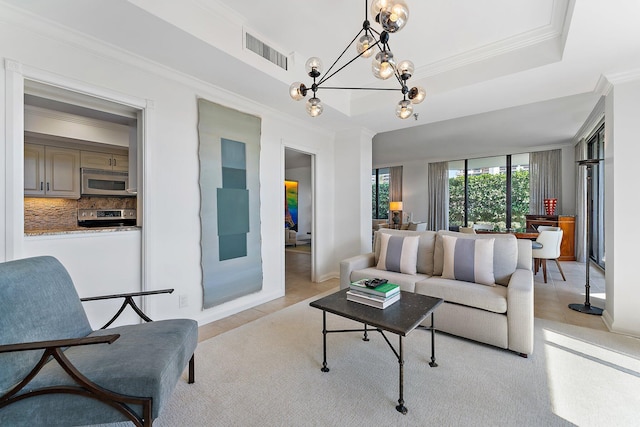 tiled living room with ornamental molding, a tray ceiling, and a notable chandelier