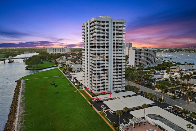 aerial view at dusk featuring a water view