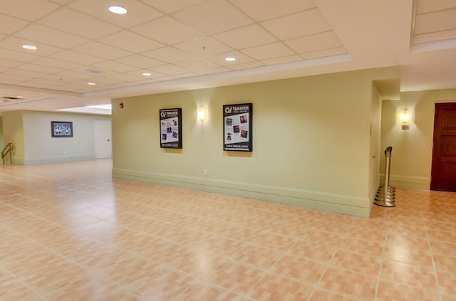 interior space with light tile floors and a drop ceiling