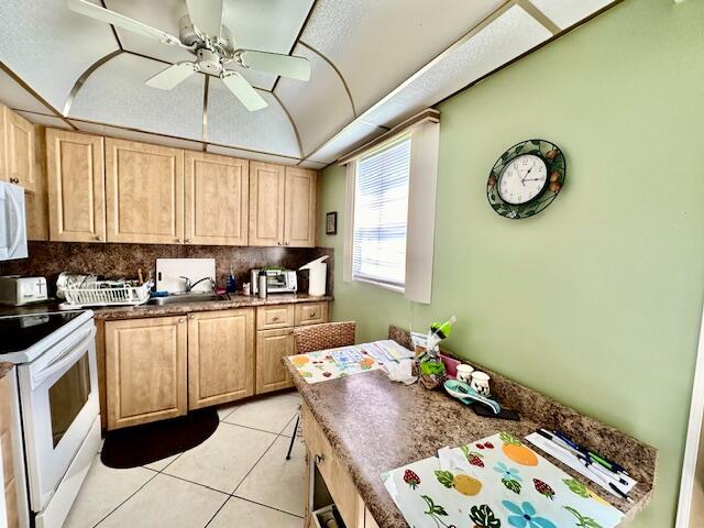 kitchen with white appliances, backsplash, ceiling fan, and light tile floors