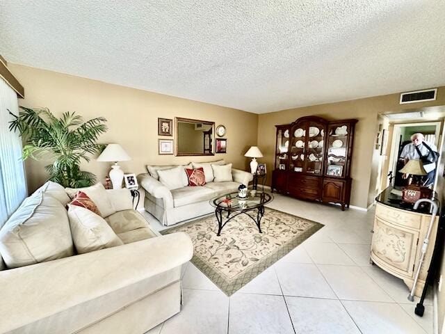 living room with a textured ceiling and light tile flooring