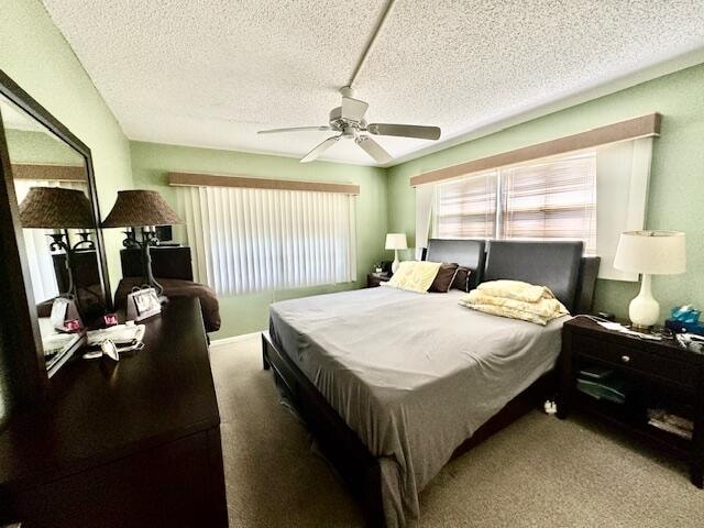 carpeted bedroom with a textured ceiling and ceiling fan