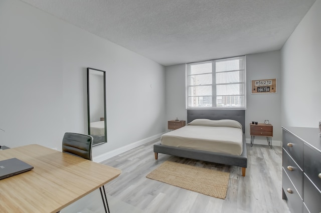 bedroom with light hardwood / wood-style flooring and a textured ceiling