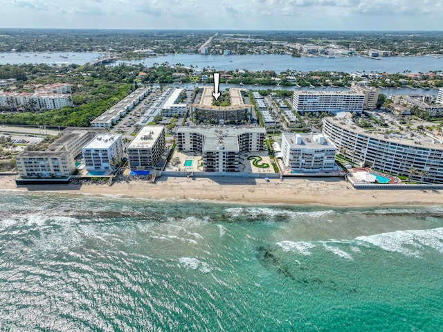 birds eye view of property featuring a water view and a beach view