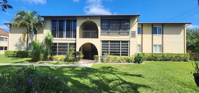 view of front of house featuring a balcony and a front yard