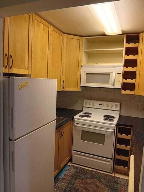 kitchen with backsplash and white appliances