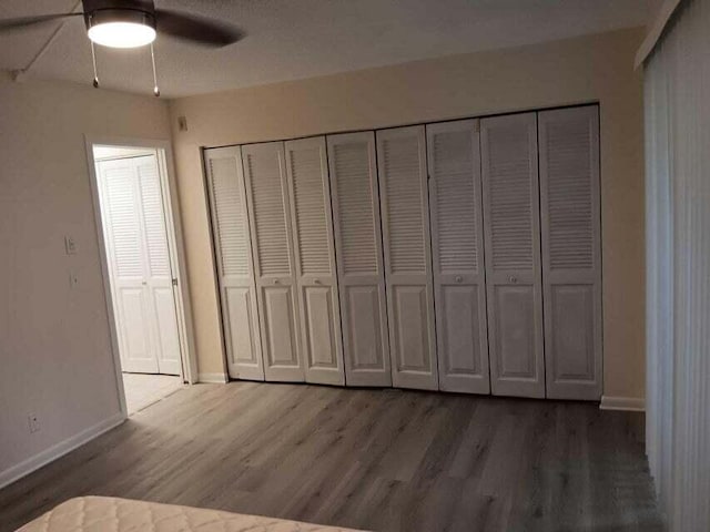 unfurnished bedroom featuring dark hardwood / wood-style floors and ceiling fan