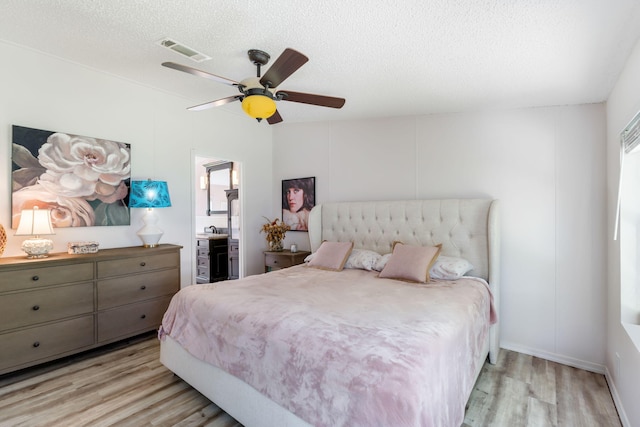 bedroom featuring ceiling fan, light hardwood / wood-style flooring, and a textured ceiling