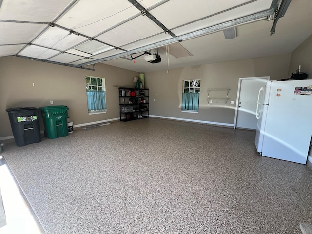 garage with a garage door opener and white fridge