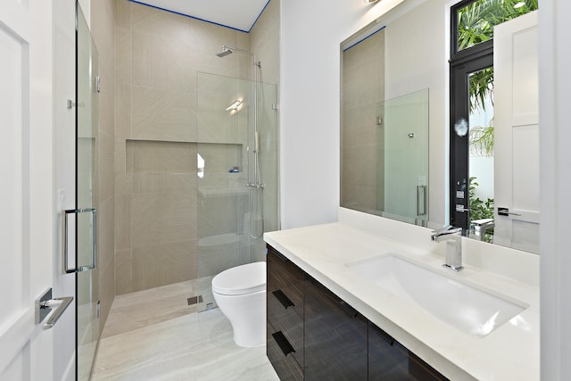 bathroom featuring walk in shower, toilet, and vanity with extensive cabinet space