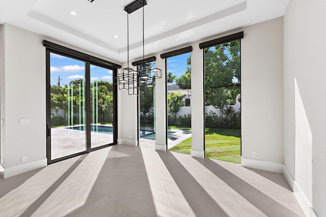 empty room featuring a chandelier and a tray ceiling