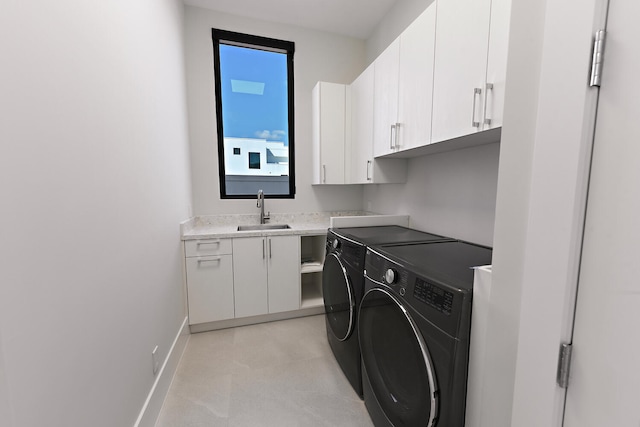 laundry room with cabinets, washing machine and clothes dryer, sink, and light tile flooring