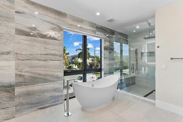 bathroom featuring tile walls, tile flooring, and separate shower and tub