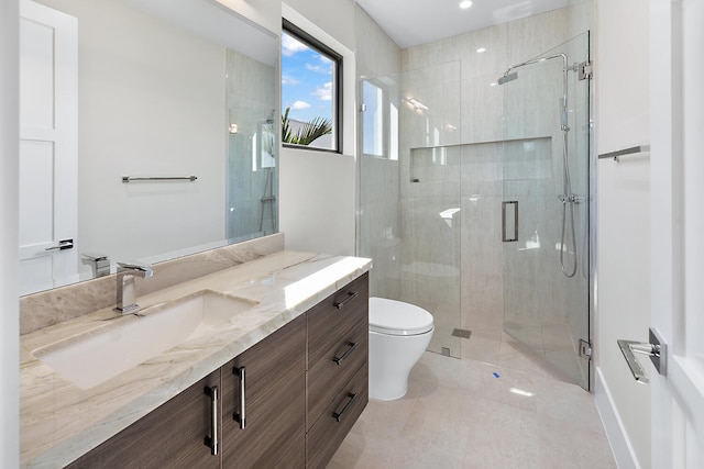 bathroom featuring a shower with door, tile floors, oversized vanity, and toilet