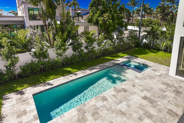 view of swimming pool featuring an in ground hot tub, a lawn, and a patio