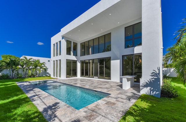 back of property featuring a fenced in pool, a patio area, and a yard