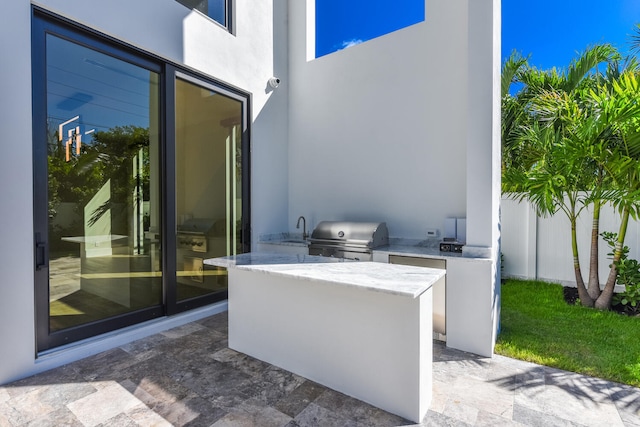 view of terrace featuring exterior kitchen, area for grilling, and sink