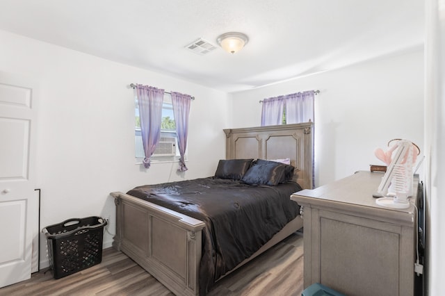 bedroom with light hardwood / wood-style flooring and cooling unit