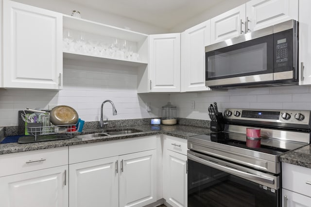 kitchen featuring decorative backsplash, white cabinets, stainless steel appliances, and sink