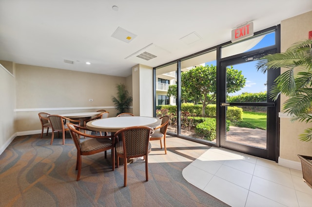 dining room featuring expansive windows and light tile floors