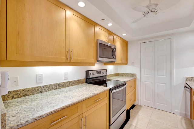 kitchen featuring ceiling fan, light tile floors, stainless steel appliances, and light stone countertops