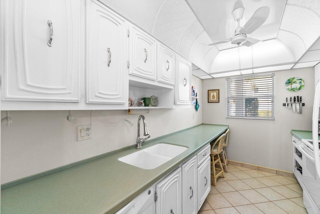 kitchen with light tile floors, white cabinetry, ceiling fan, and sink