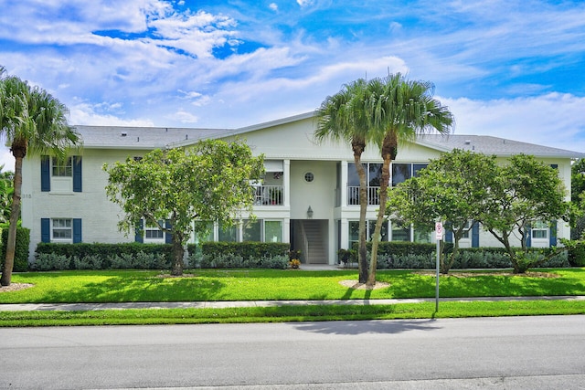 view of front of property featuring a front lawn and a balcony