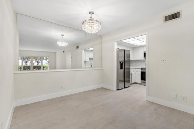 unfurnished room with a chandelier