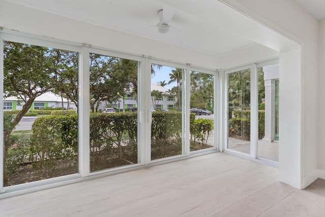 unfurnished sunroom featuring a healthy amount of sunlight and ceiling fan