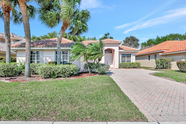 mediterranean / spanish house featuring a front yard