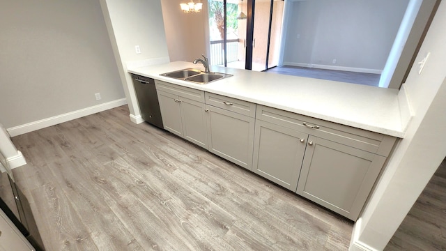 kitchen with sink, gray cabinets, dishwasher, light hardwood / wood-style floors, and a notable chandelier