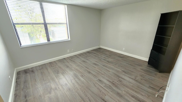 spare room with hardwood / wood-style floors and a textured ceiling