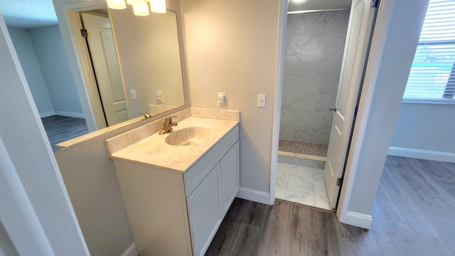 bathroom featuring a tile shower, vanity, and hardwood / wood-style flooring