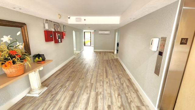 hallway featuring an AC wall unit and light wood-type flooring