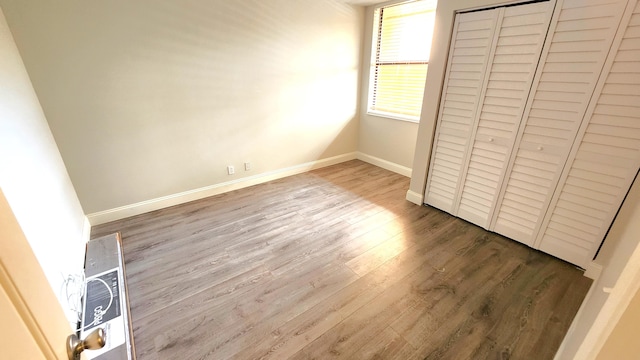 unfurnished bedroom featuring a closet and light hardwood / wood-style flooring