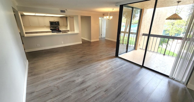 kitchen featuring ornamental molding, wood-type flooring, pendant lighting, and a chandelier