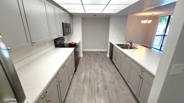 kitchen featuring sink, electric range, gray cabinetry, a chandelier, and light wood-type flooring