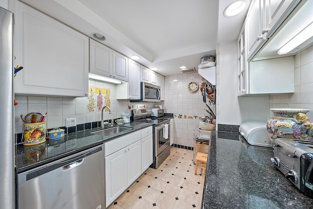 kitchen featuring dark stone countertops, sink, white cabinets, and appliances with stainless steel finishes