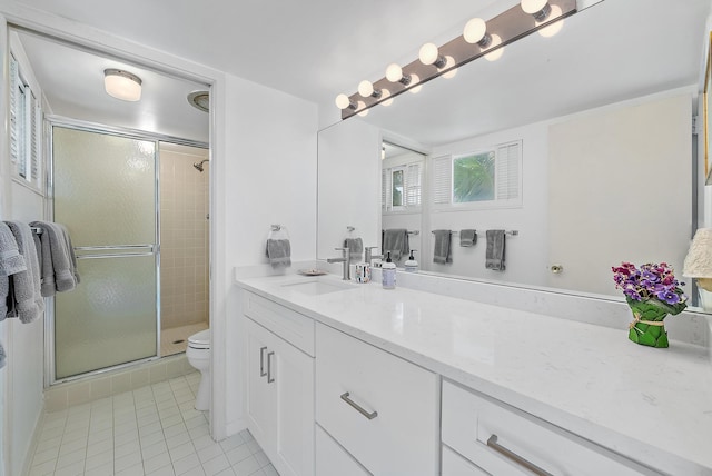 bathroom featuring tile patterned flooring, vanity, toilet, and a shower with door