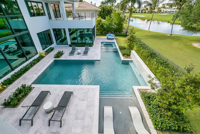 view of pool with a patio, a water view, and a yard