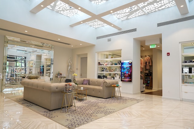 living room featuring light tile floors and a towering ceiling