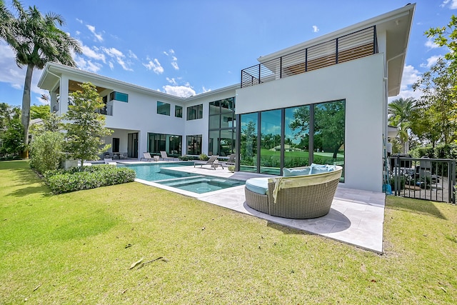 back of property featuring a lawn, a balcony, and a patio area